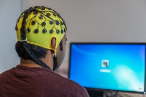 Image of a man with an EEG cap on participating in Neurofeedback Training at the Center for Neurocognitive Excellence.