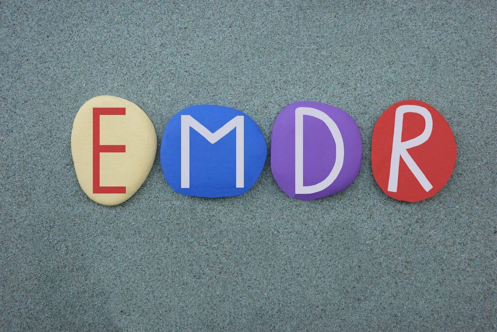 Colorful stones painted to form the letters EMDR. EMDR Therapy in Washington, DC is a proven effective treatment for dealing with the effects of trauma.