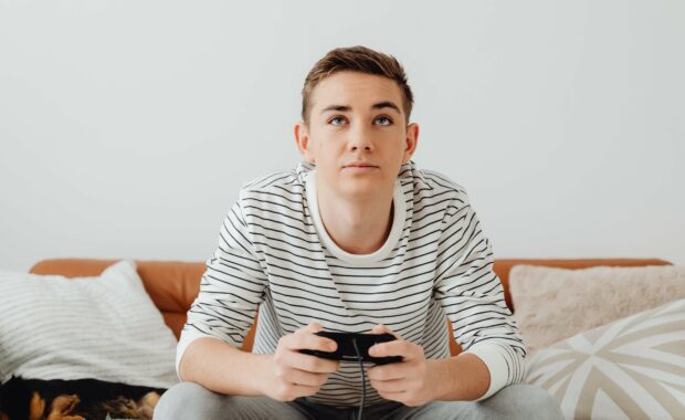 A young man plays video games during the holiday season. Connecting virtually can help combat holiday anxiety. Learn more in Anxiety Therapy in Washington, DC.