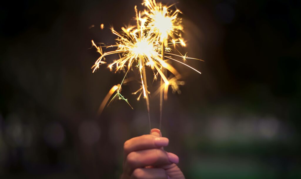 A hand holds a sparkler ringing in the new year representing the light at the end of the tunnel when you overcome depression with Therapy for Depression in Washington, DC.
