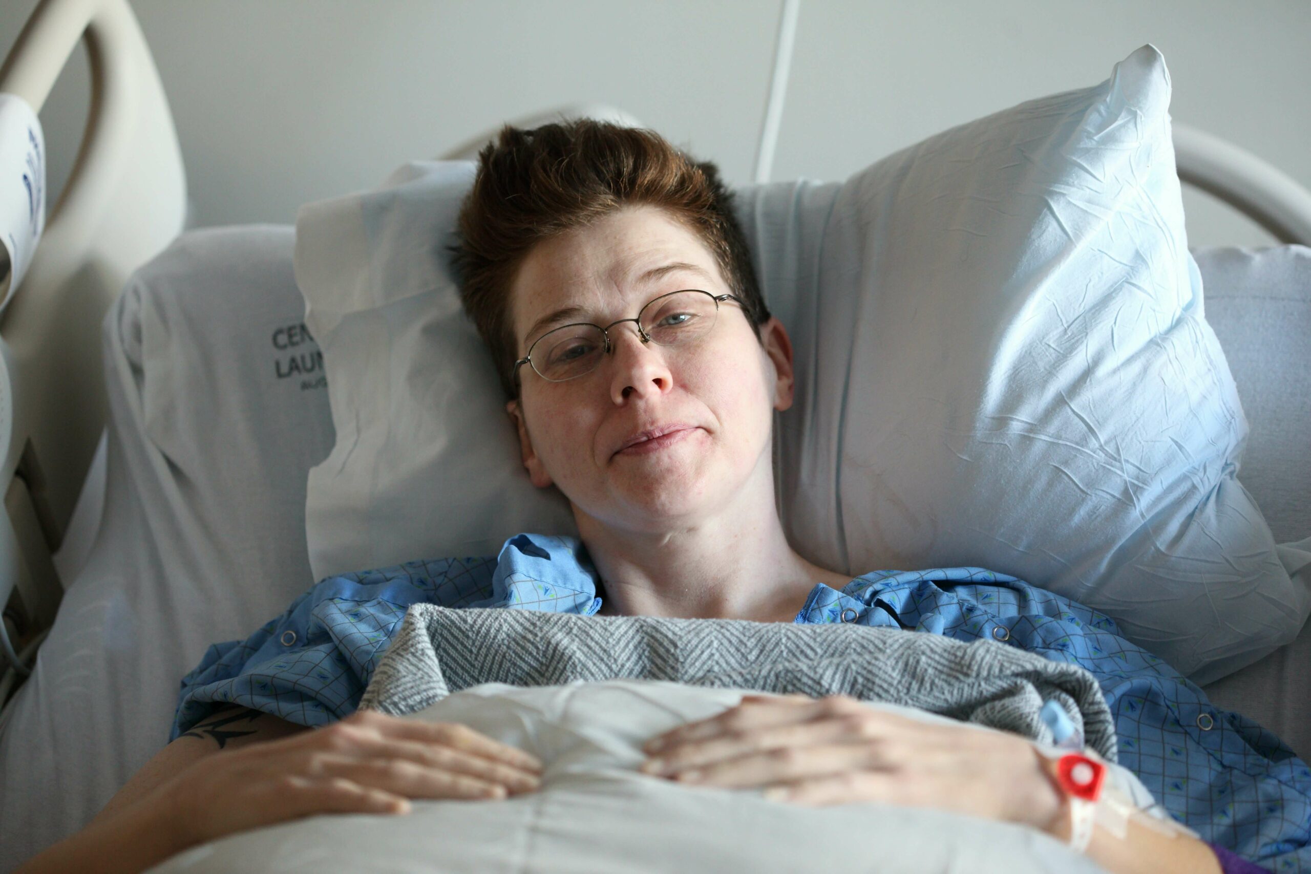A woman laying down in a bed in the hospital.