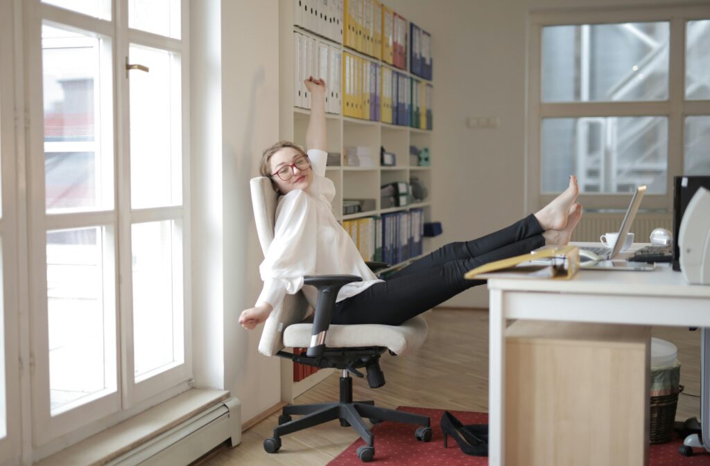 Dreamy female employee relaxing with feet on table in office. DCNE offers Therapy for ADHD in Washington DC.