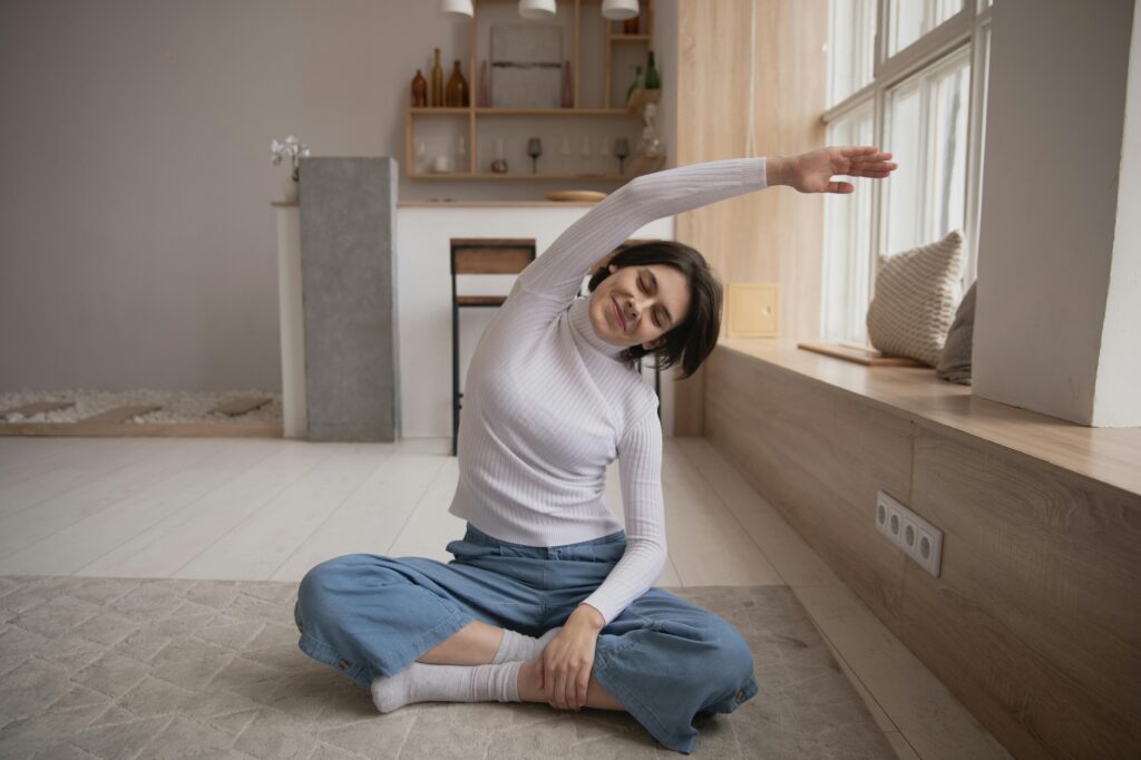 Smiling woman practicing yoga with closed eyes at home. DCNE offers Therapy for ADHD in Washington DC.