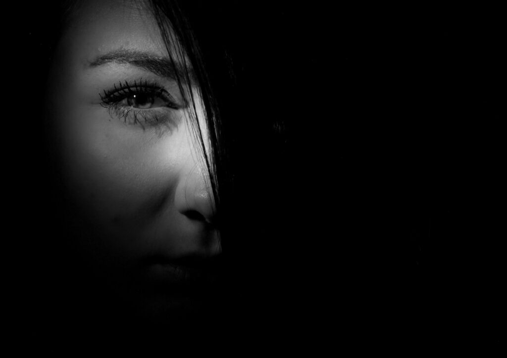 A photo of a woman's face in the shadows. 