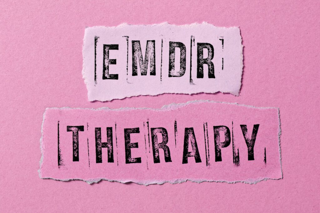 Torn paper strips showing EMDR therapy for anxiety treatment concept on pink background