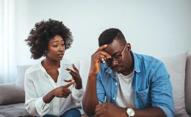 Woman having supportive conversation with male partner about mental health and therapy in comfortable home setting