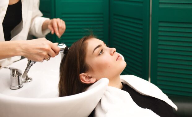 Client at shampoo bowl in Washington DC salon contemplating personal struggles, illustrating the hairapist phenomenon where stylists hear mental health disclosures